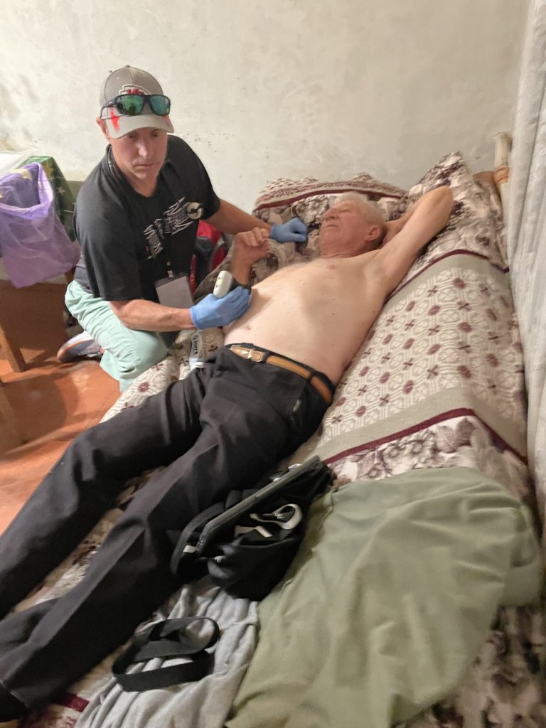 Mark Haffey performs an ultrasound on a patient in Ukraine.
